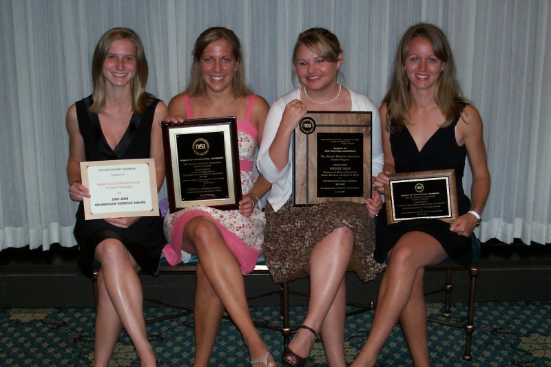 Four members of the Student Education Association of Maine smiling for the camera, holding awards 