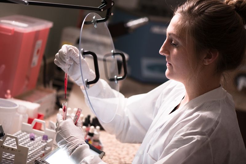 MLT Student in a lab coat running a blood test