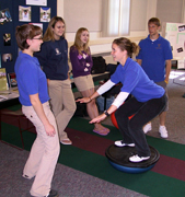 Student demonstrating balance trainer to four others