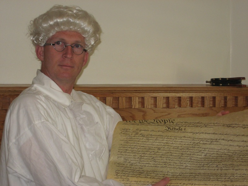 Photo of person holding up the first page of the US Constitution