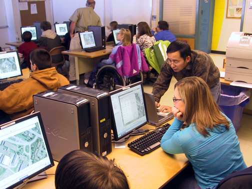 Students being taught in a computer lab by two teachers