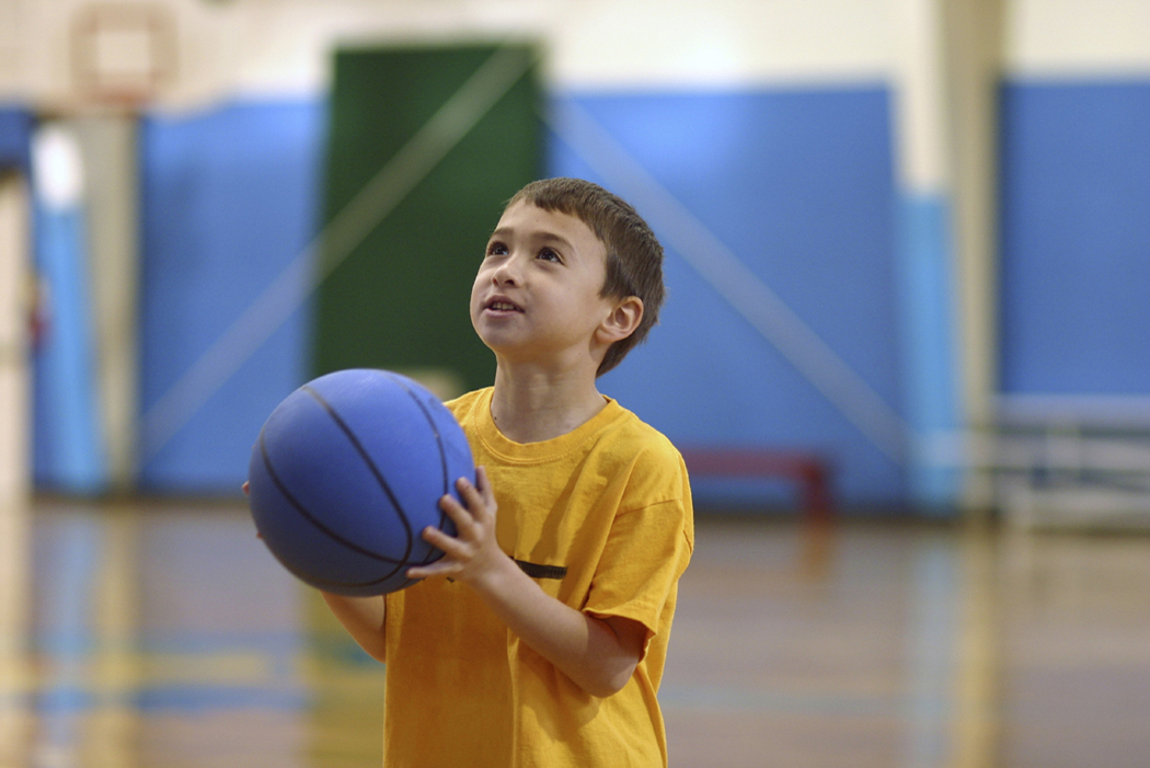 Photo of child holding a blue basketball