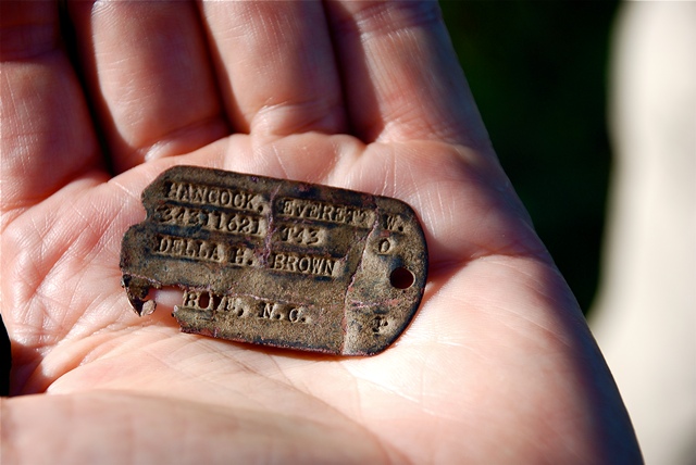 Photo of dog tag of Della H. Brown with patina