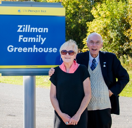 Photo of Don and Linda Zillman next to Zillman Family Greenhouse sign.