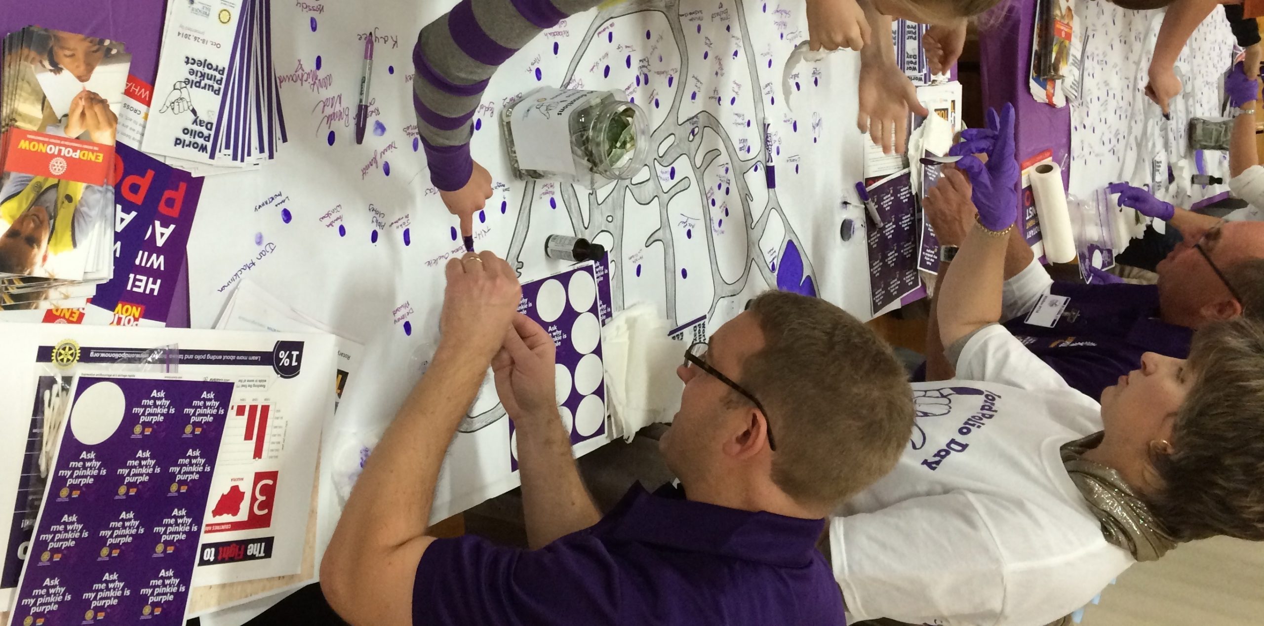 Photo of people making purple pinky prints on Purple Pinky Day event