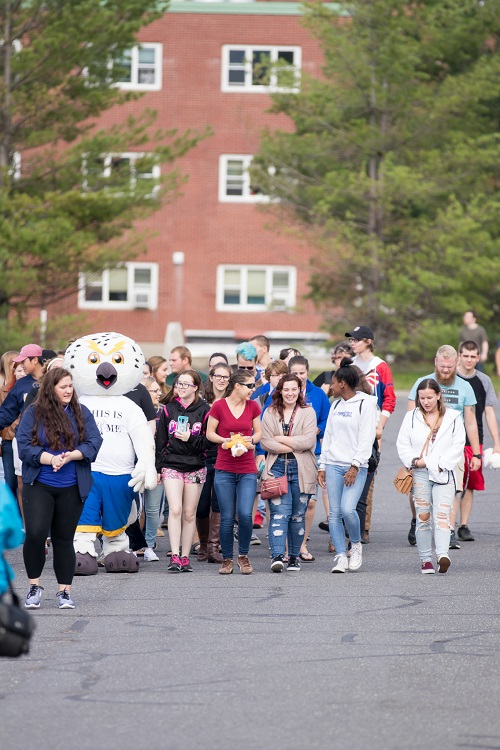 Photo with many newly-accepted students walking outside with UMPI's owl mascot