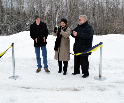 Photo of three people at the ribbon-cutting of UMPI's new ice skating rink