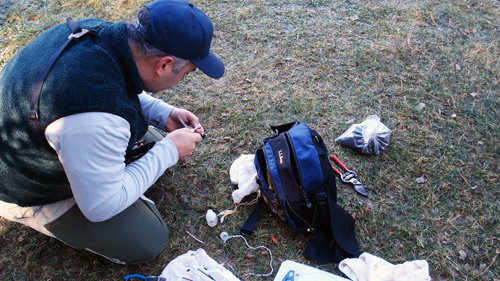 Jason Johnston preparing to do research outside with tools and instruments in a backpack