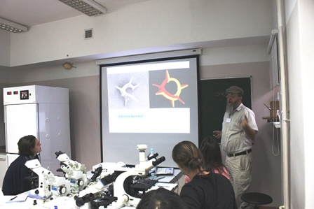 Photo of Professor McCartney teaching students, using a projector as a teaching aid