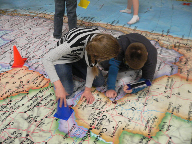 Photo of two students on a giant map