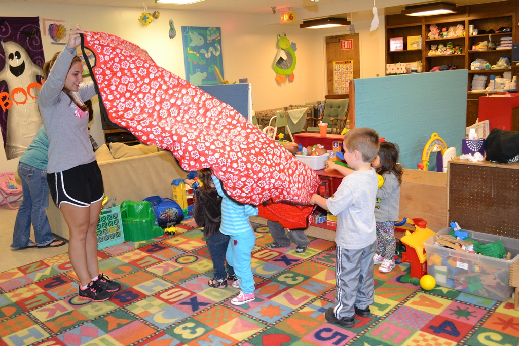 Photo of UMPI P.E. student working with five children at a daycare