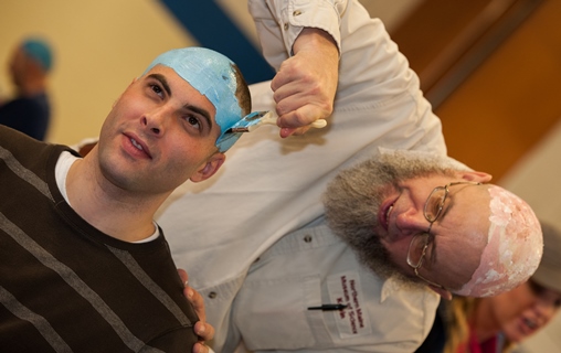 Student getting his head painted blue for Planet Head Day