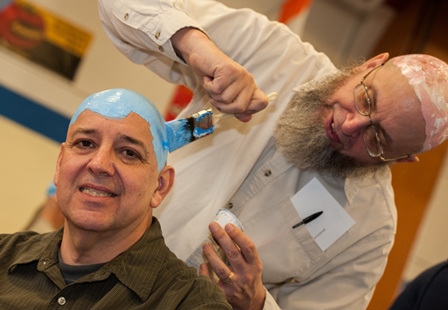 Photo of Dr. McCartney painting someone's head blue for Planet Head Day