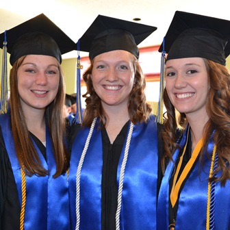 Photo of three smiling graduates