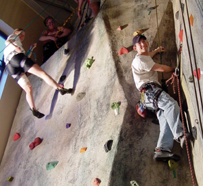 Photo of three students using the rock wall