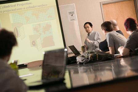 Photo of professor teaching in a classroom using a projector as an aid