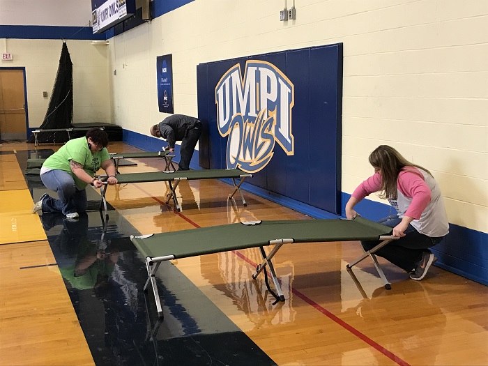 ACAP and UMPI staffers set up cots for the temporary wellness shelter in Wieden Gym.