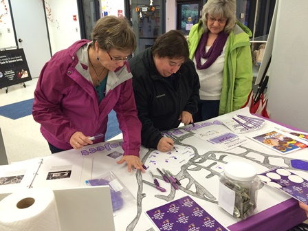 Photo of three people preparing materials for "Purple Pinky Project"