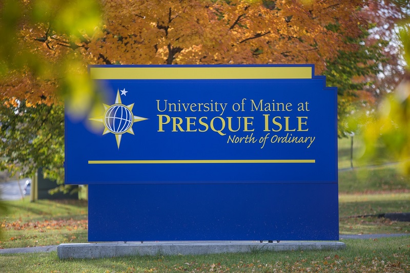 Photo of UMPI sign in front of fall foliage.